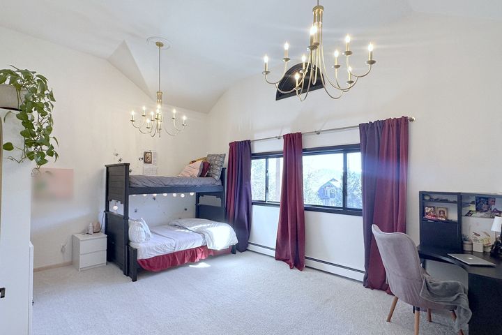 Kids' room with bunk beds, chandeliers and a desk